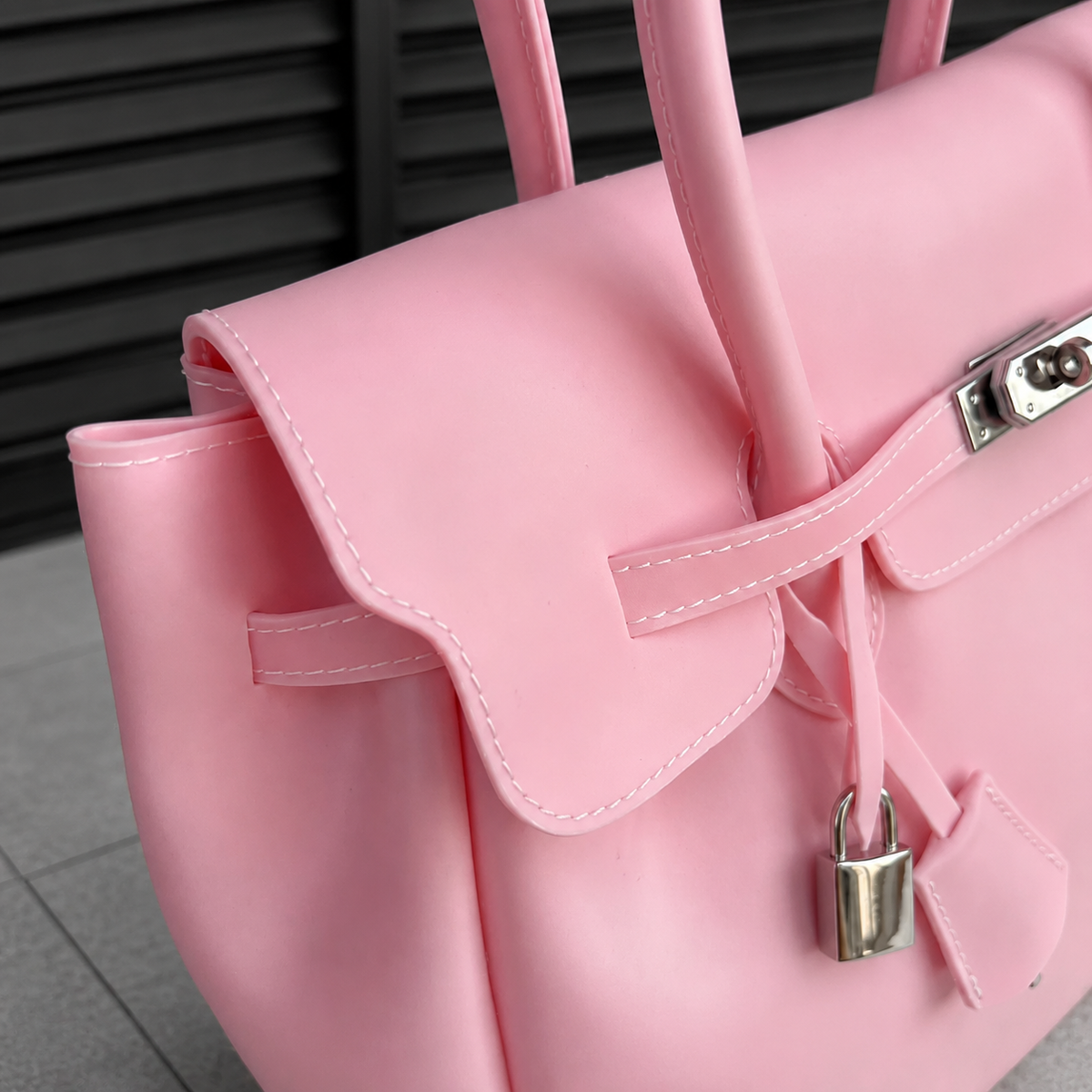 Gros plan sur le fermoir cadenas et les surpiqûres du sac Jelly Firkin Blush rose poudré