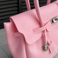 Gros plan sur le fermoir cadenas et les surpiqûres du sac Jelly Firkin Blush rose poudré