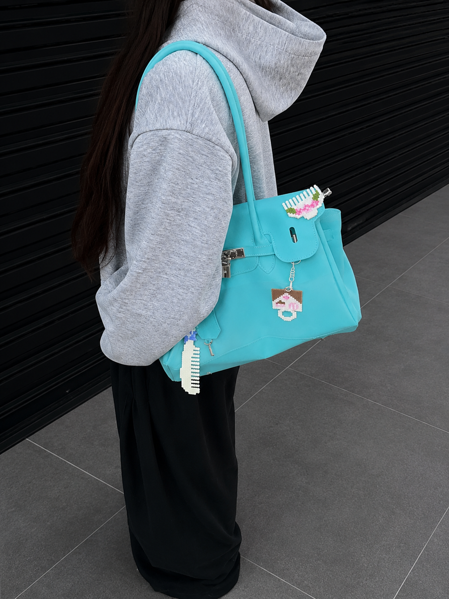 Sac Jelly Firkin Sky bleu ciel porté à l'épaule avec breloques, look streetwear décontracté