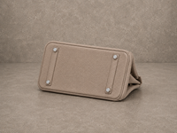 Dessous du sac Jelly Élan Grège, base en cuir grainé beige grège protégée par des pieds métalliques