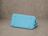 Dessous du sac Jelly Élan Celeste, base en cuir grainé bleu ciel protégée par des pieds métalliques