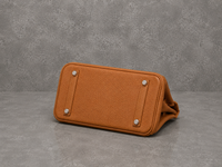 Dessous du sac Jelly Élan Ambre, base en cuir grainé brun ambré protégée par des pieds métalliques