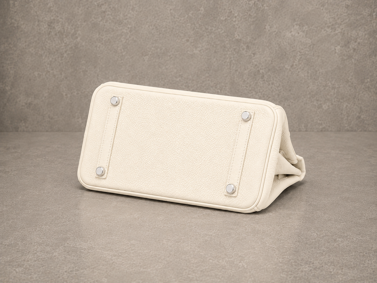 Dessous du sac Jelly Élan Ivoire, base en cuir grainé blanc ivoire protégée par des pieds métalliques