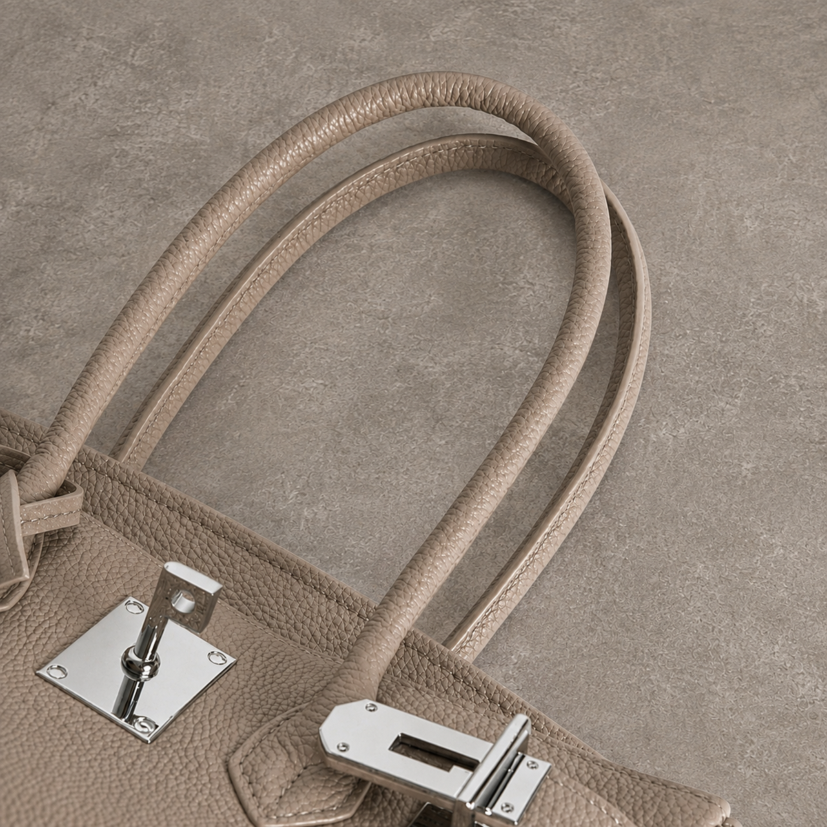 Anses et ferrure argentée du sac Jelly Élan Grège vues du dessus, cuir véritable grainé