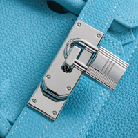 Gros plan sur le fermoir cadenas argenté du sac Elan Bag Celeste en cuir grainé