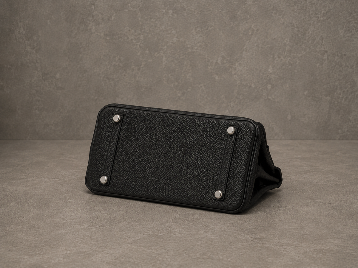 Dessous du sac Elan Bag Ébène, base en cuir grainé noir ébène protégée par des pieds métalliques
