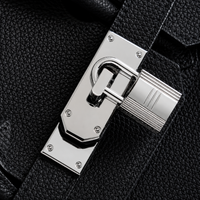 Gros plan sur le fermoir cadenas argenté du sac Elan Bag Ébène en cuir grainé